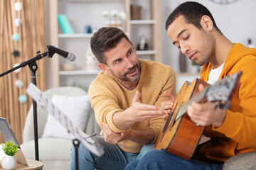 musician teaching student acousitc guitar