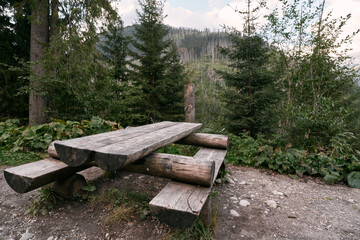 Fototapeta na wymiar Empty outdoor wooden furniture in the Tatra National Park. Concept of having a picnic outdoors with a beautiful mountain view.