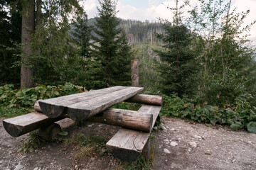 Empty outdoor wooden furniture in the Tatra National Park. Concept of having a picnic outdoors with a beautiful mountain view.