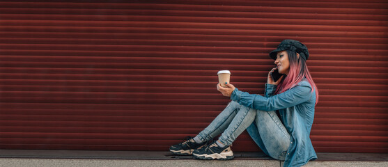 girl talking on the mobile phone outdoors with a blind on a red background