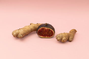 Ginger root and cut figs on a pink background