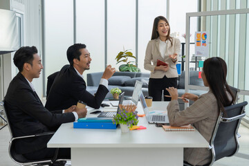 Asian female mentor coaching and mentoring businessman and businesswoman listening attentively.