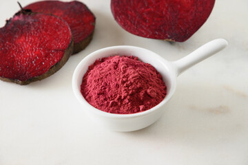 Beetroot powder for cooking healthy beverage in bowl and beetroot vegetable on white marble...