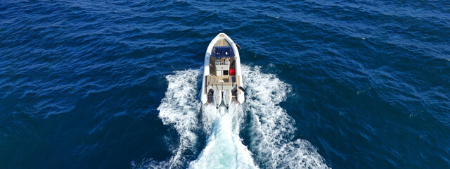 Aerial drone top down ultra wide photo with copy space of inflatable speed boat with wooden deck...