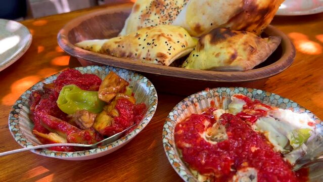 Traditional Turkish Meze dishes with fresh pide ekmek bread in Bodrum Turkey, tasty eggplant starters, 4K shot