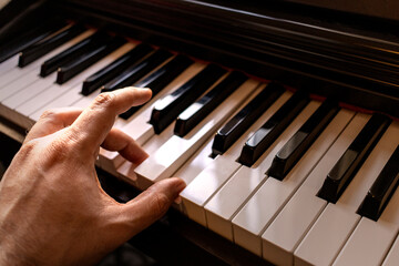 Fototapeta na wymiar Man playing the piano. Man's hand playing chords on the piano.
