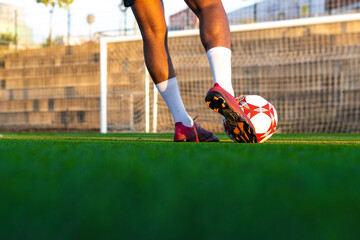 Football player feet running with the ball in front of the field. Player feet with the ball scoring a goal. Football player on the field running with the ball
