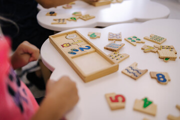 Children in kindergarten put together educational puzzles