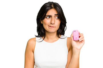 Young Indian woman holding a car keys isolated confused, feels doubtful and unsure.