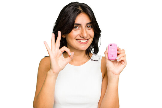 Young Indian woman holding a car keys isolated cheerful and confident showing ok gesture.