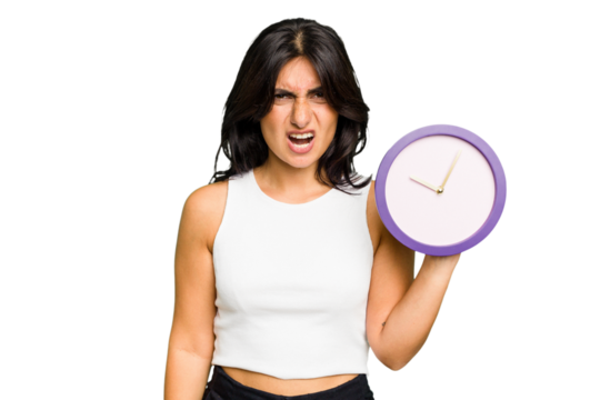 Young Indian woman holding a clock isolated screaming very angry and aggressive. - Powered by Adobe
