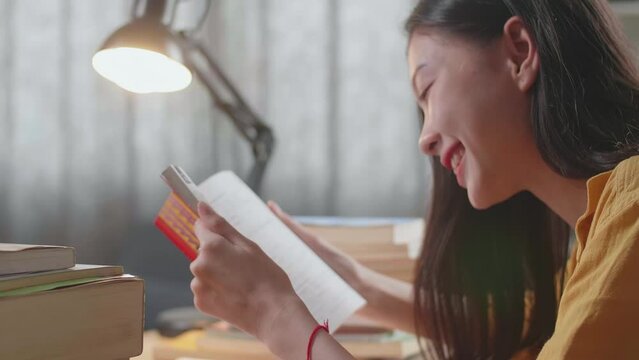 Close Up Of Young Asian Female Reading Books While Studying At Home
