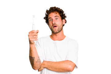Young caucasian man holding an electric toothbrush isolated having some great idea, concept of creativity.