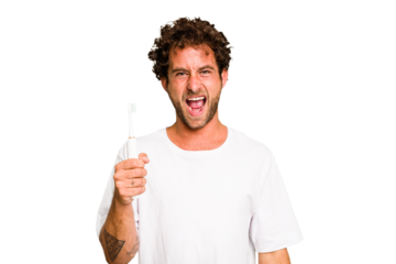 Young caucasian man holding an electric toothbrush isolated screaming very angry and aggressive.