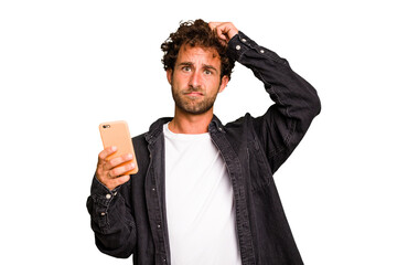 Young caucasian man using mobile phone isolated being shocked, she has remembered important meeting. - obrazy, fototapety, plakaty