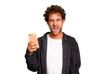 Young caucasian man using mobile phone isolated screaming very angry and aggressive.