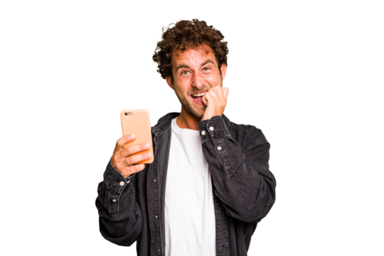 Young caucasian man using mobile phone isolated biting fingernails, nervous and very anxious.