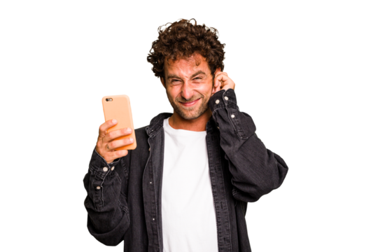 Young caucasian man using mobile phone isolated covering ears with hands.