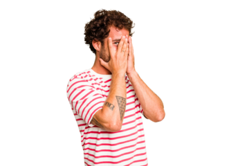 Young caucasian curly hair man isolated Young caucasian man with curly hair isolated blink through fingers frightened and nervous.