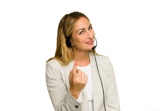 Telemarketer caucasian woman working with a headset isolated on green chroma background pointing with finger at you as if inviting come closer.