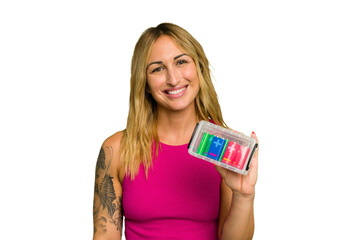 Young caucasian woman holding battery box isolated on green chroma background happy, smiling and cheerful.