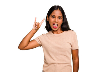 Young Indian woman isolated showing a horns gesture as a revolution concept.
