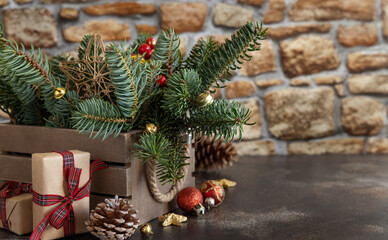 Wrapped gift boxes near Christmas decorations, pine cones and green fir branches