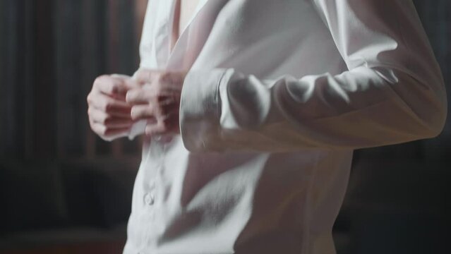 Close Up Of A Man Putting On And Buttoning White Classic Shirt. Dressing For Celebration Event, Business Meeting Or Wedding
