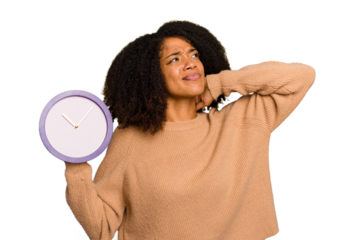 Young African American holding a clock isolated touching back of head, thinking and making a choice.