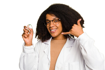 Young otorhinolaryngologist African american woman holding hearing aid isolated showing a mobile...