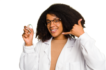 Young otorhinolaryngologist African american woman holding hearing aid isolated showing a mobile phone call gesture with fingers.