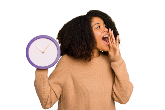 Young African American holding a clock isolated shouting and holding palm near opened mouth.