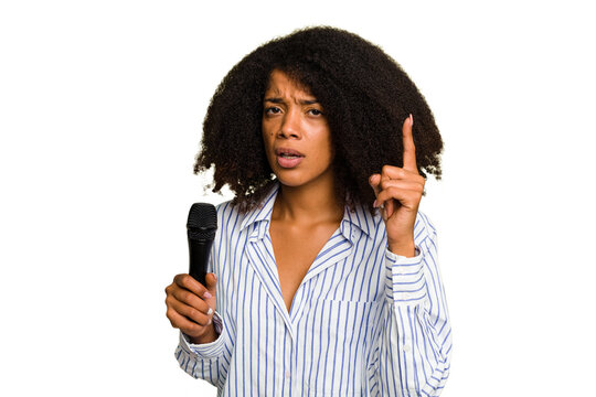 Young African American singer woman holding a microphone isolated having an idea, inspiration concept.