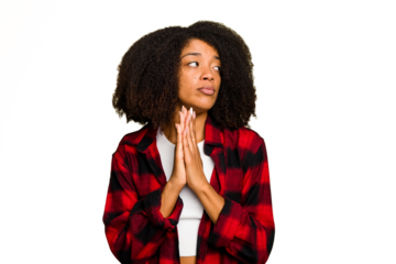 Young African American woman isolated praying, showing devotion, religious person looking for divine inspiration.