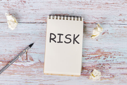 The Word Risk Is Written On A Notebook. The Concept Of An Unpredictable Situation.