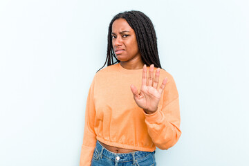 Young African American woman with braids hair isolated on blue background rejecting someone showing...