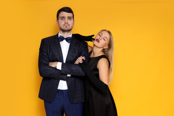 Concept of Halloween, young man and woman on yellow background