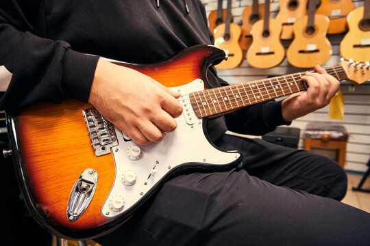 Man Playing The Guitar In The Guitar Shop