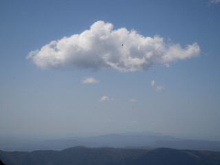 Clouds in the sky from a hill with birds flying around