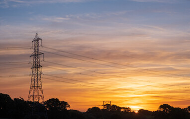 Electricity pylons at orange sunset
