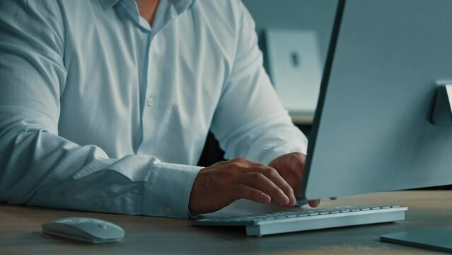 Unknown businessman programmer male worker IT specialist man work in office typing on modern keyboard using personal computer developing internet software check database programming business online 