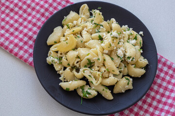 Pasta with cheese on a black plate. Italian Popular Italian food.