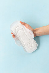White pad in female hand. Menstruation period and daily hygiene concept © 9dreamstudio