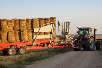 Tractor transporting bales of straw