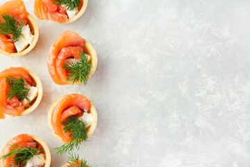 Snack with red fish on a light table. Festive snack. Menu for the festive table. View from above. Copy space.