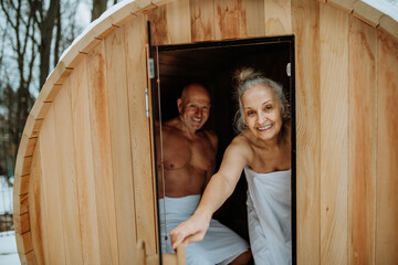 Senior couple enjoying together time in wooden sauna, relax, spa and healthy lifestlye concept.