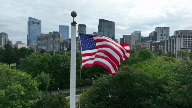 Downtown Boston Massachusetts with USA flag. Aerial establishing shot of skyline and State House dome.