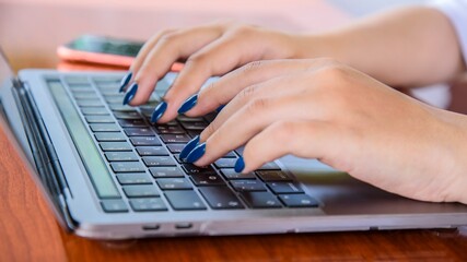 Women's hands work on the keyboard. Close-up. Focus at the center of the picture.