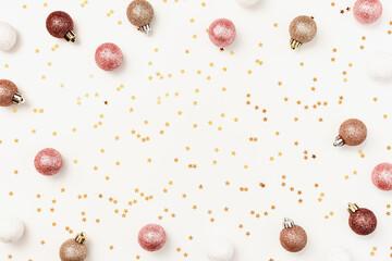 Christmas holiday frame from pink beige decorations trend sparkling xmas toys, shining Christmas balls and golden stars around. New Year background, Happy holidays frame, top view, copy space