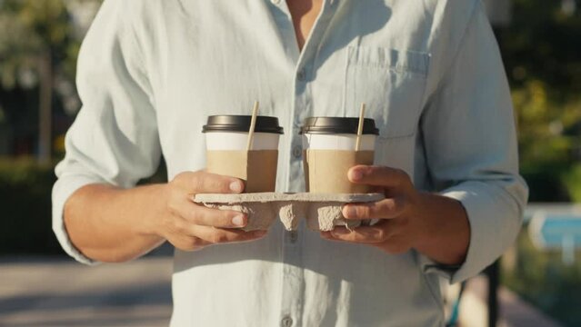Need more coffee today. Close up cropped man holding in hand holder two takeaway clear empty blank cup coffee. Service concept